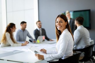 Eine Frau sitzt in einem Team-Meeting. 